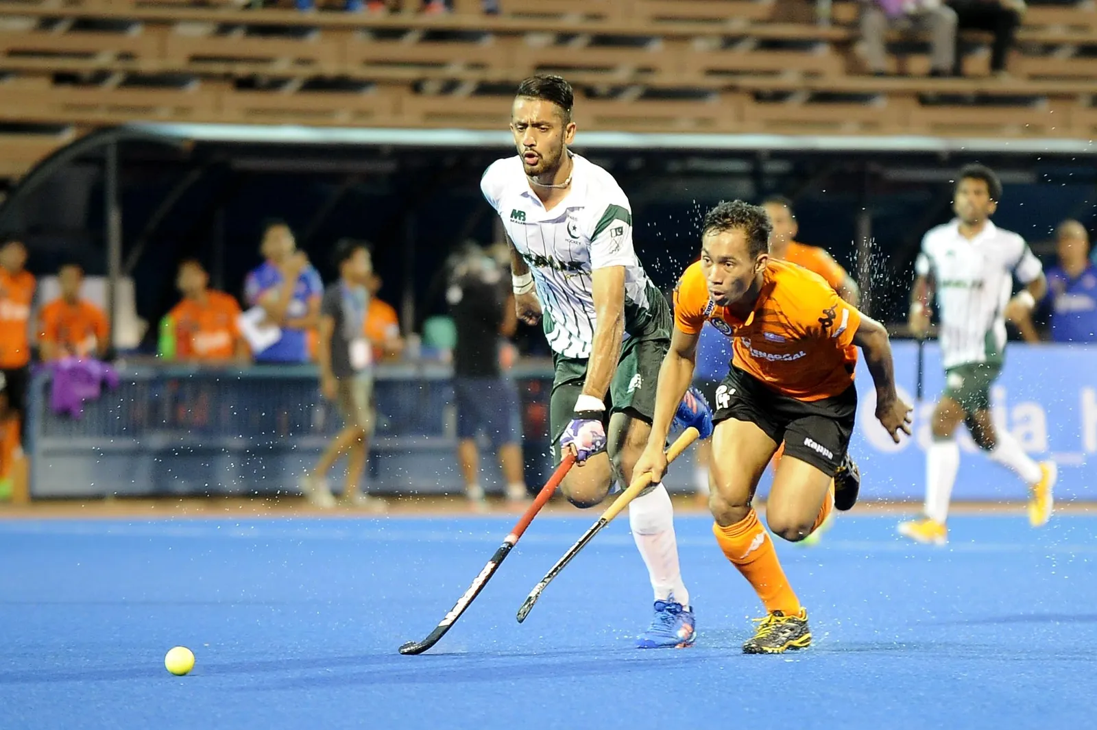 Nik Aiman Rosemi (right) races to the ball with a Pakistani defender caught on his heels during the opening match of the QNET 4th Men's Asian Champions Trophy 2016 at the Wisma Belia Hockey Stadium, Kuantan today. Malaysia won 4-2.